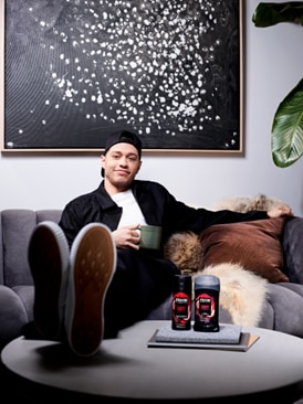Pete Davidson sitting on a couch with Axe Body Spray and Deo Stick
