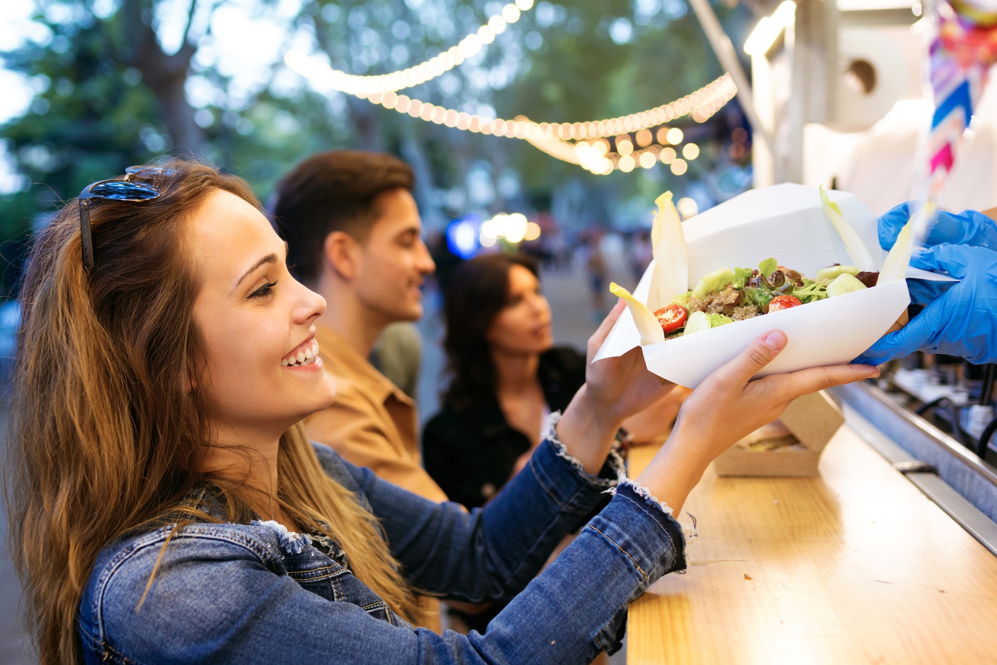 Young woman buying spicy tacos from a taco stand