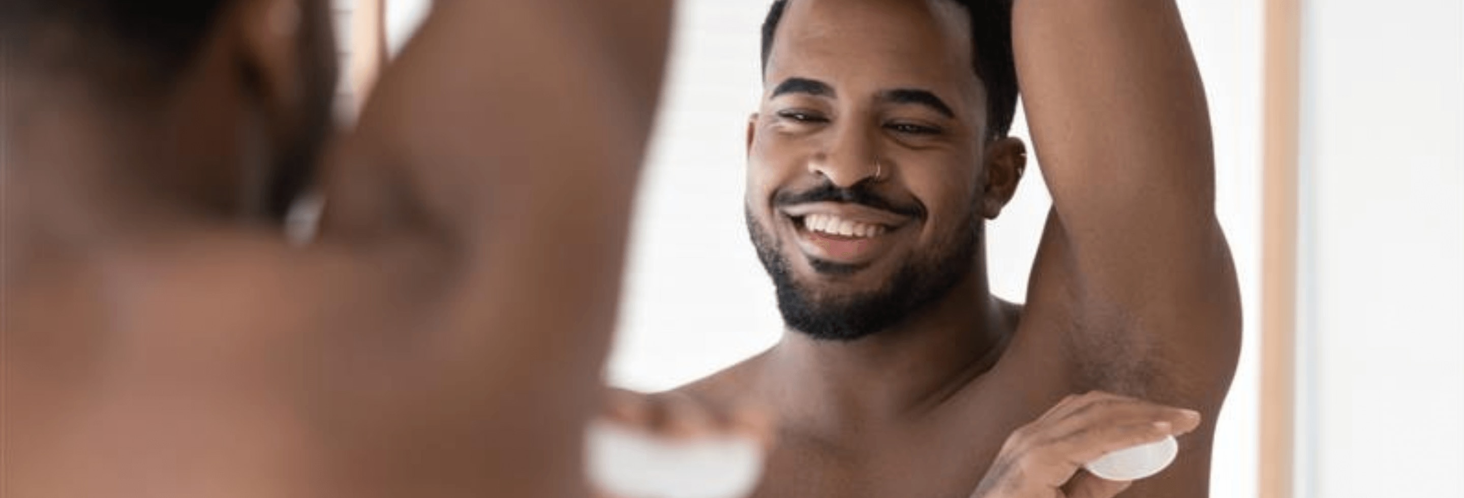 Man fresh out of the shower applying deodorant to avoid sweat after a shower