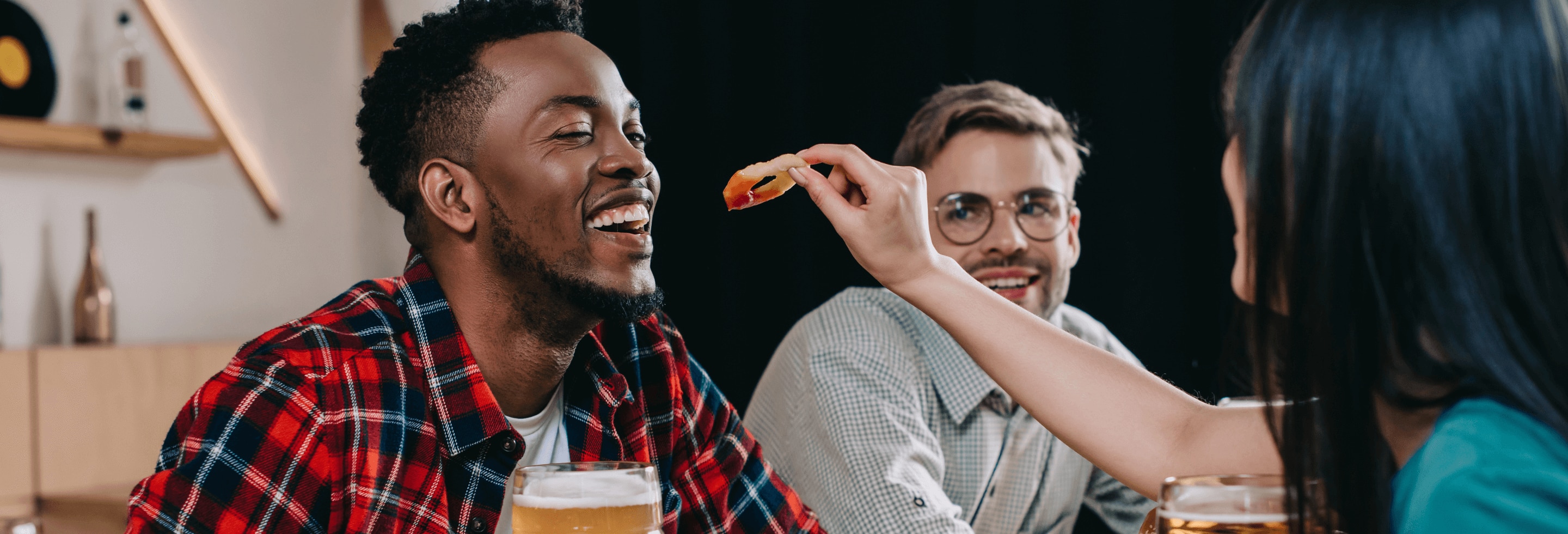 Young man eating onion rings with his friends