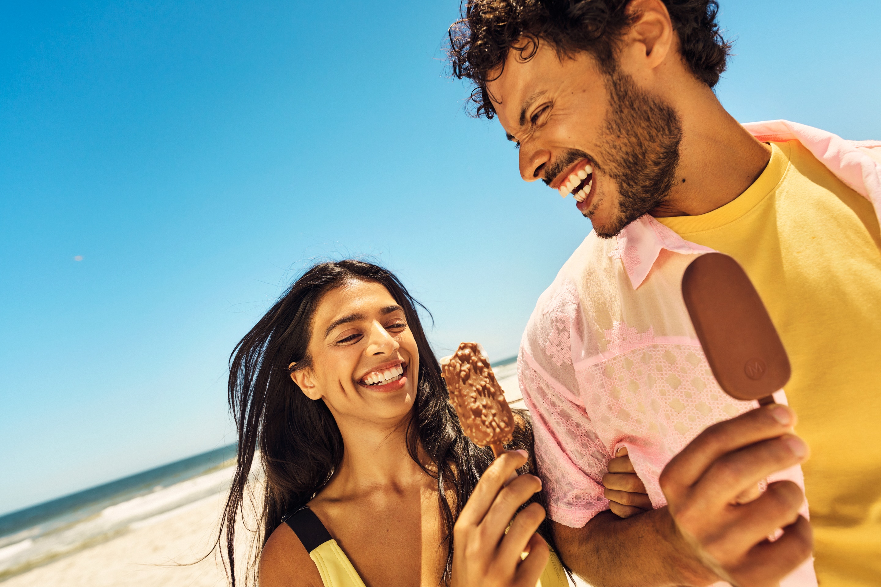 Couple laughing and holding Magnum ice creams