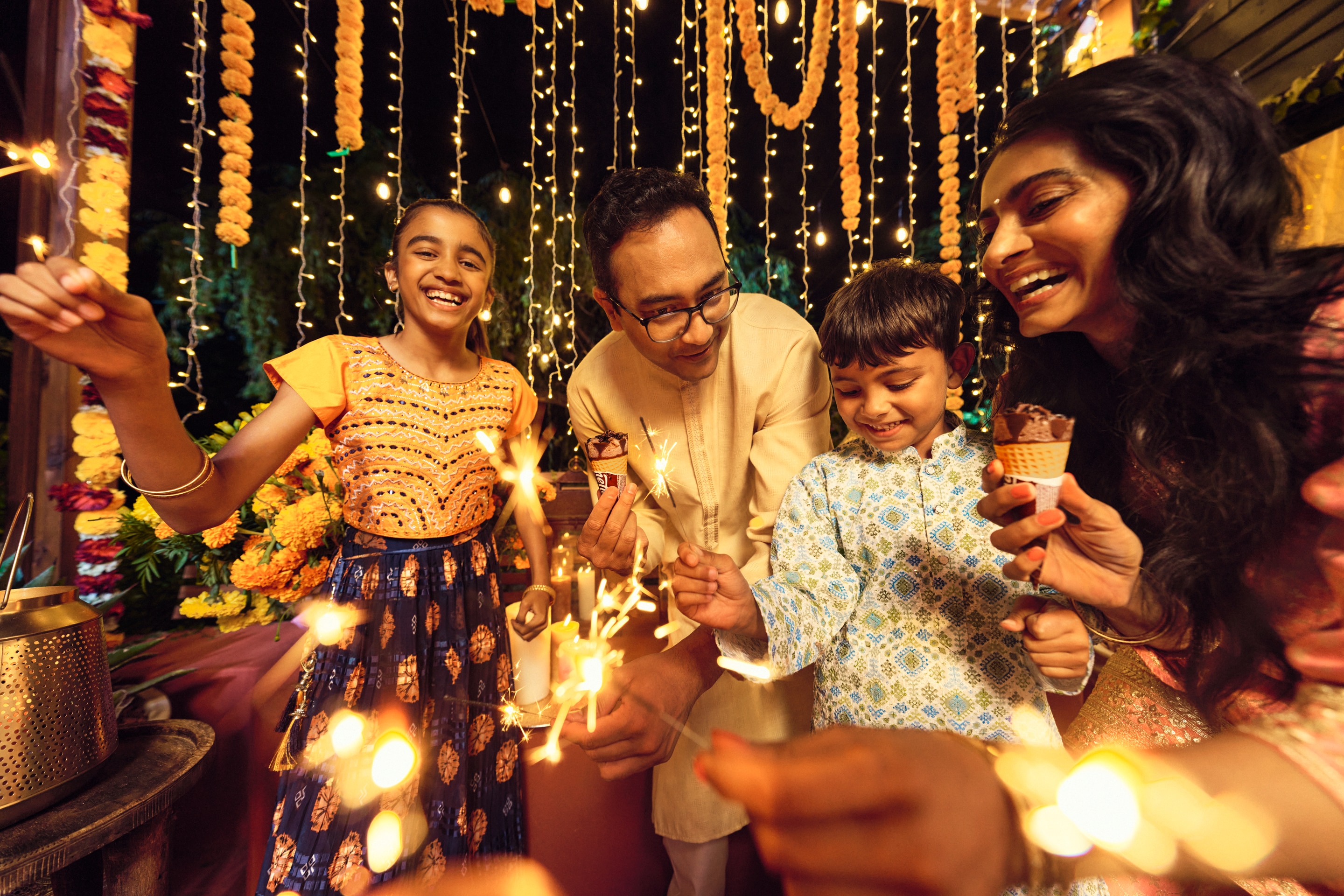 Laughing person in green top holding a popsicle in a car with friends in background.