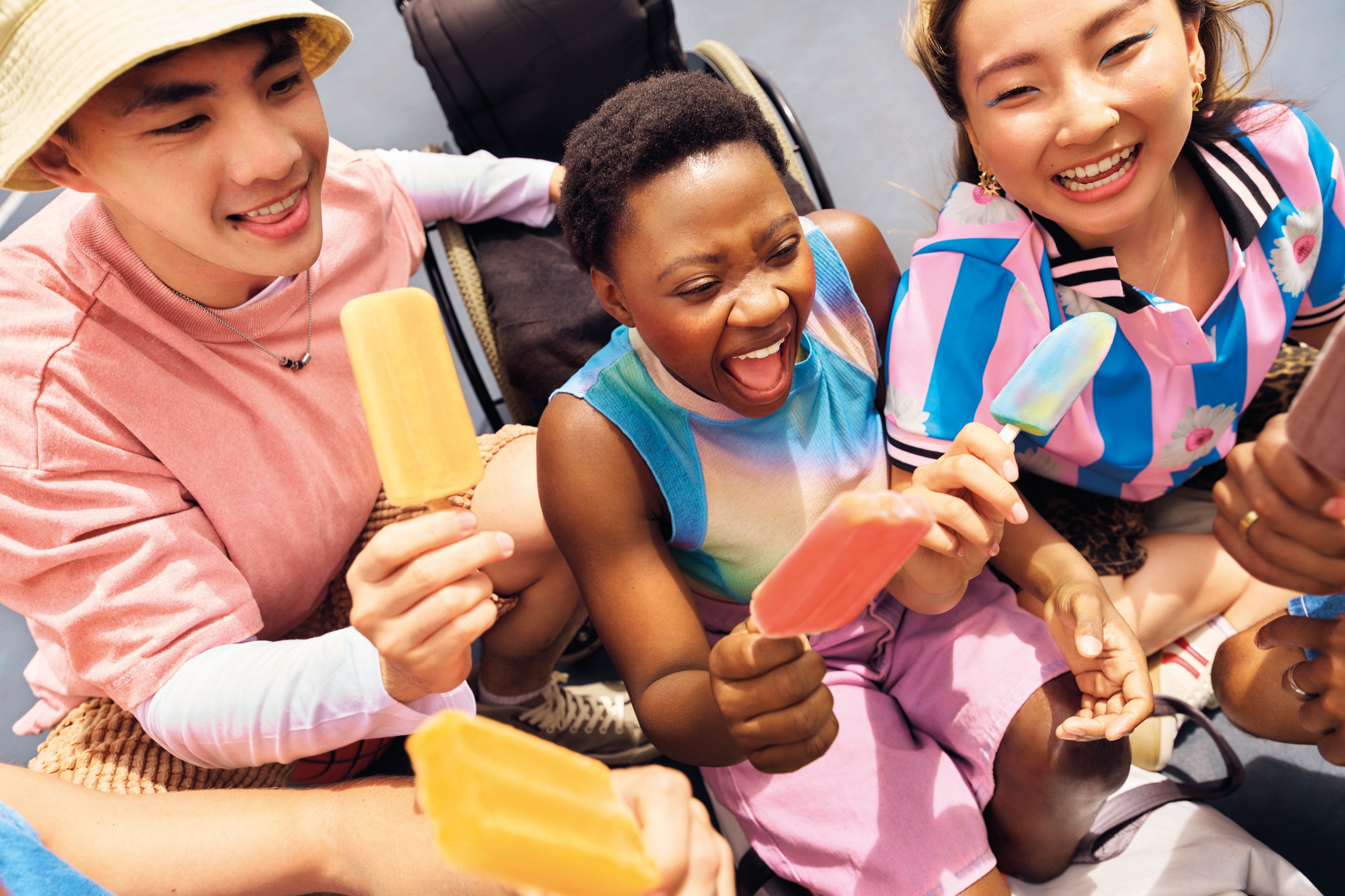 Group of people laughing and holding ice lollies