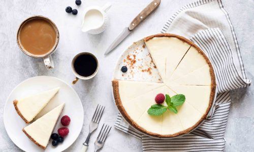 Cheese cake khas Amerika difoto vertikal bersama secangkir kopi.