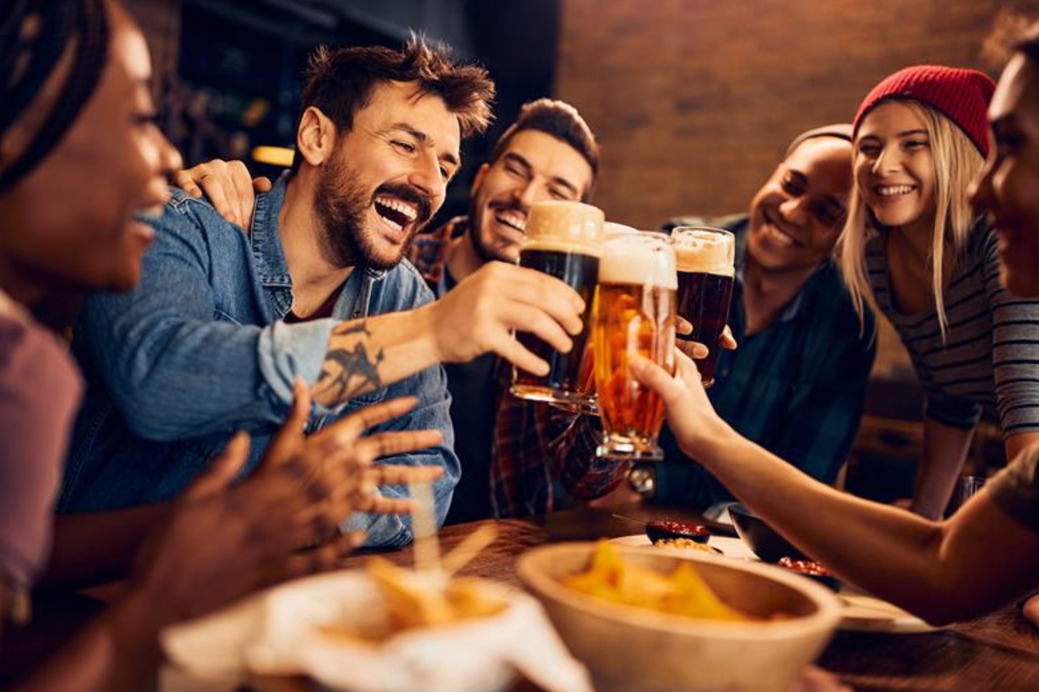 Diverse group of friends having a beer at a nearby pub with no sign of alcohol sweats 