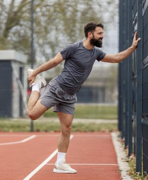 Young man stretching outdoors with no sign of sweaty balls