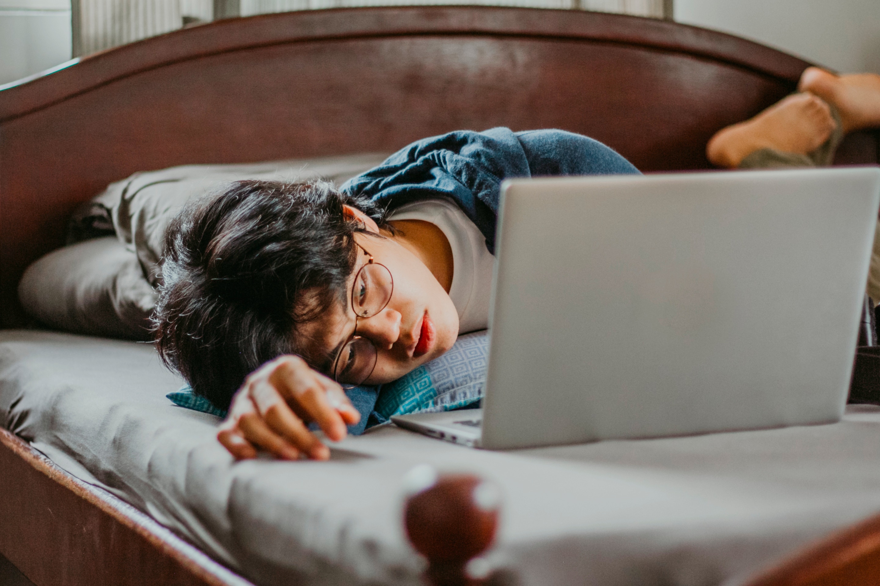 pria asia gen z yang sedang terkena jam koma dan mengantuk di depan laptop