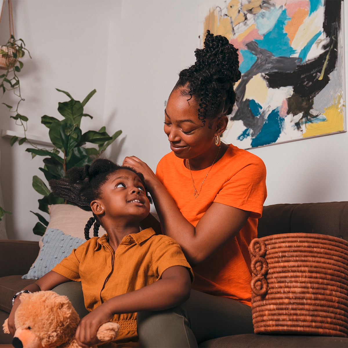 A mom braiding her daughters hair