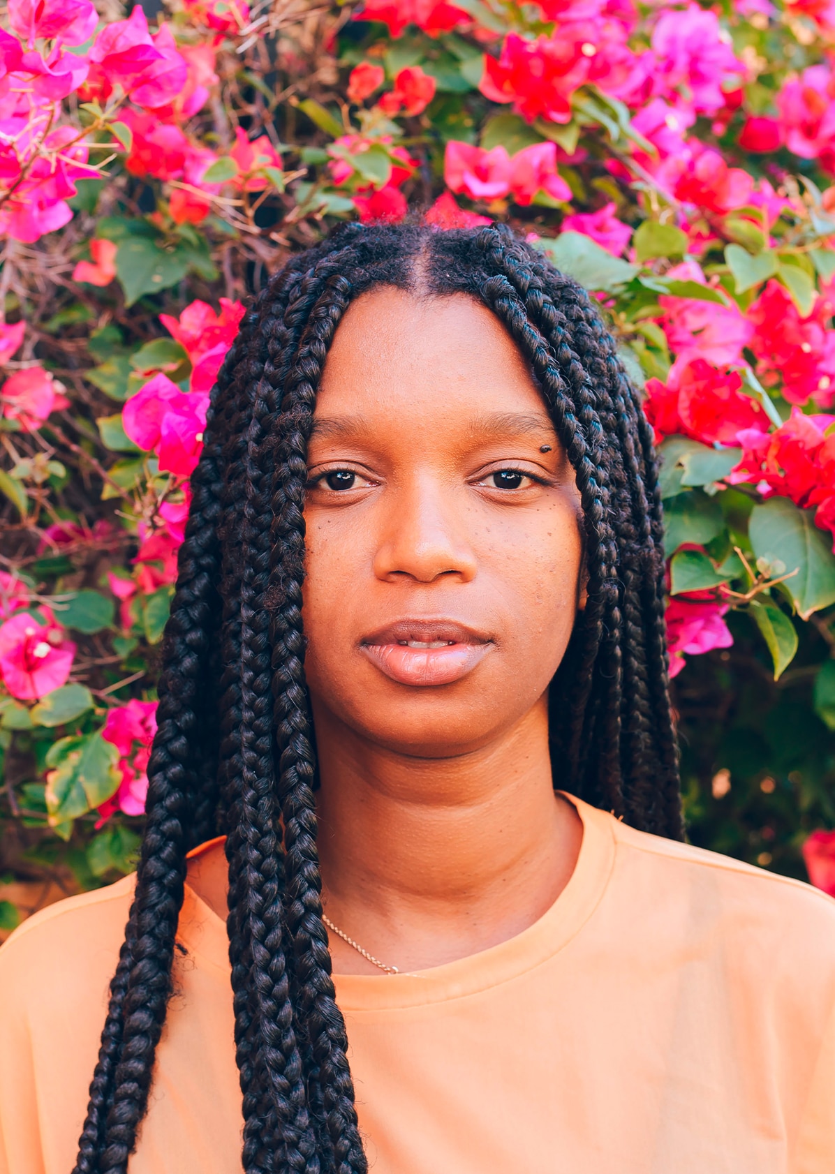 Girl smiling with floral wall behind her