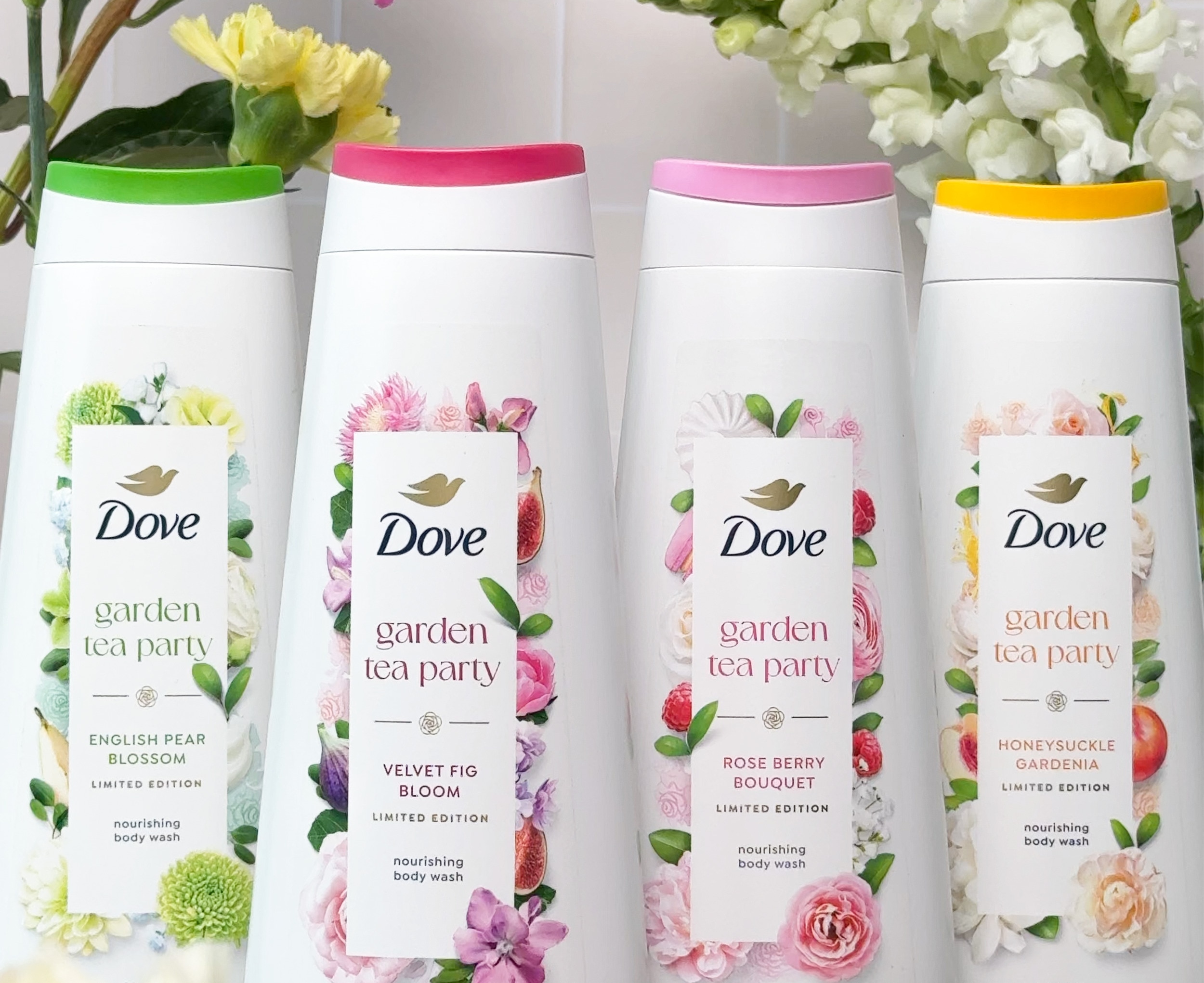 Four variants from the Dove Garden Party Body Wash collection standing against a floral background 