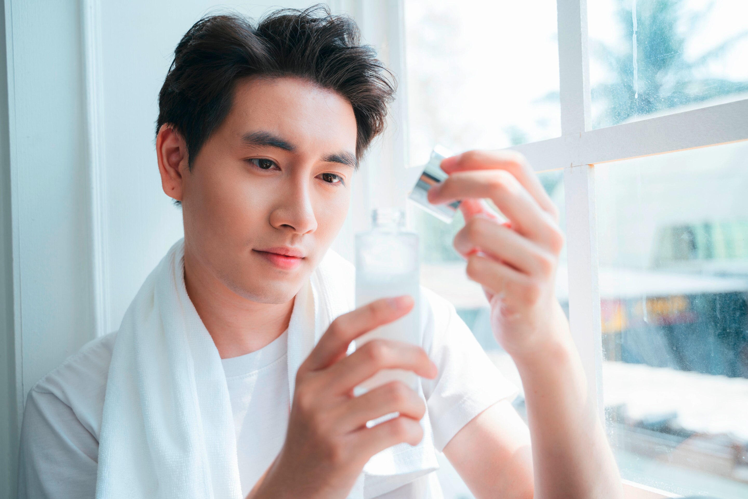 ผู้ชาย เอเชีย ถือขวดโลชั่น เตรียมบำรุงผิว ก่อนแต่งงาน