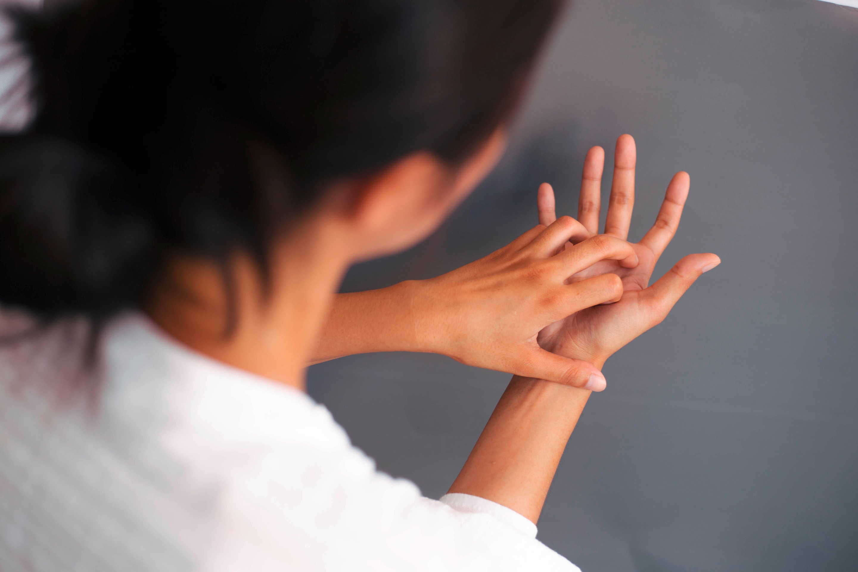 A woman examining her hands.