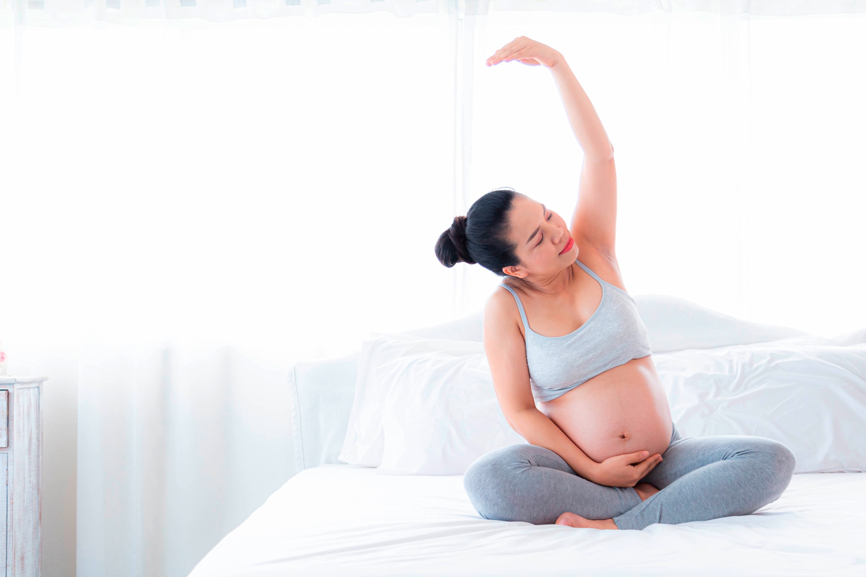 Pregnant woman stretching her arm.