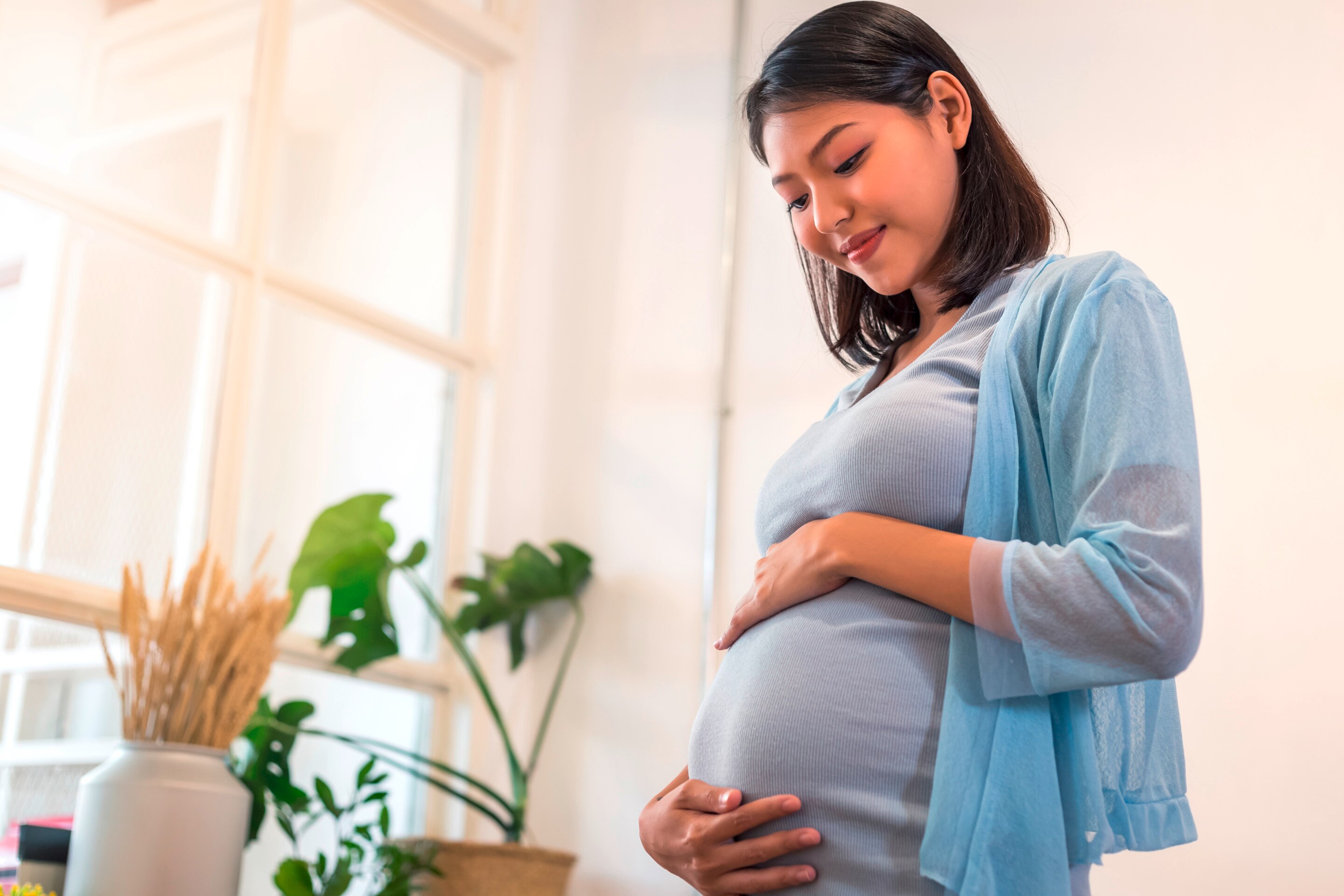 Pregnant woman looking pleased.