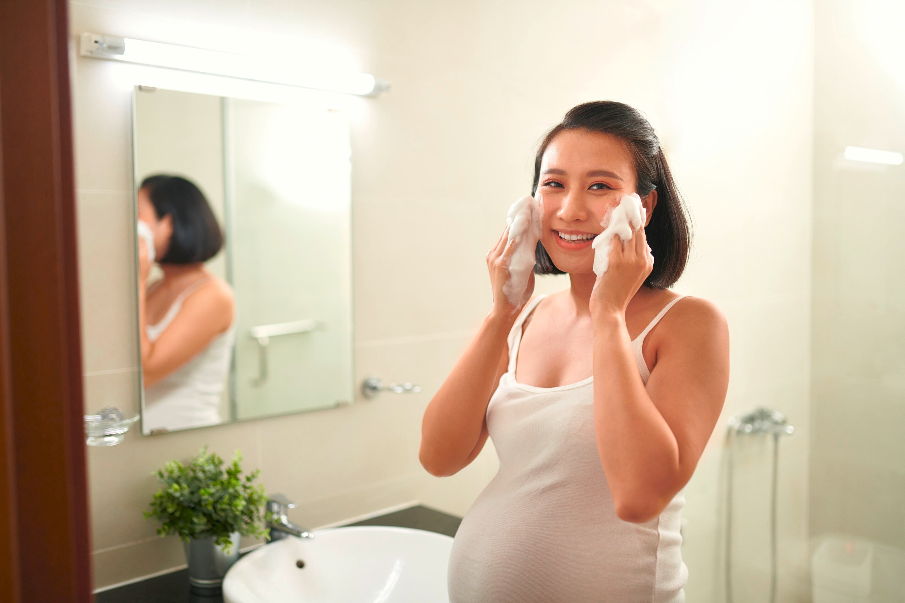 Pregnant woman washing her face.