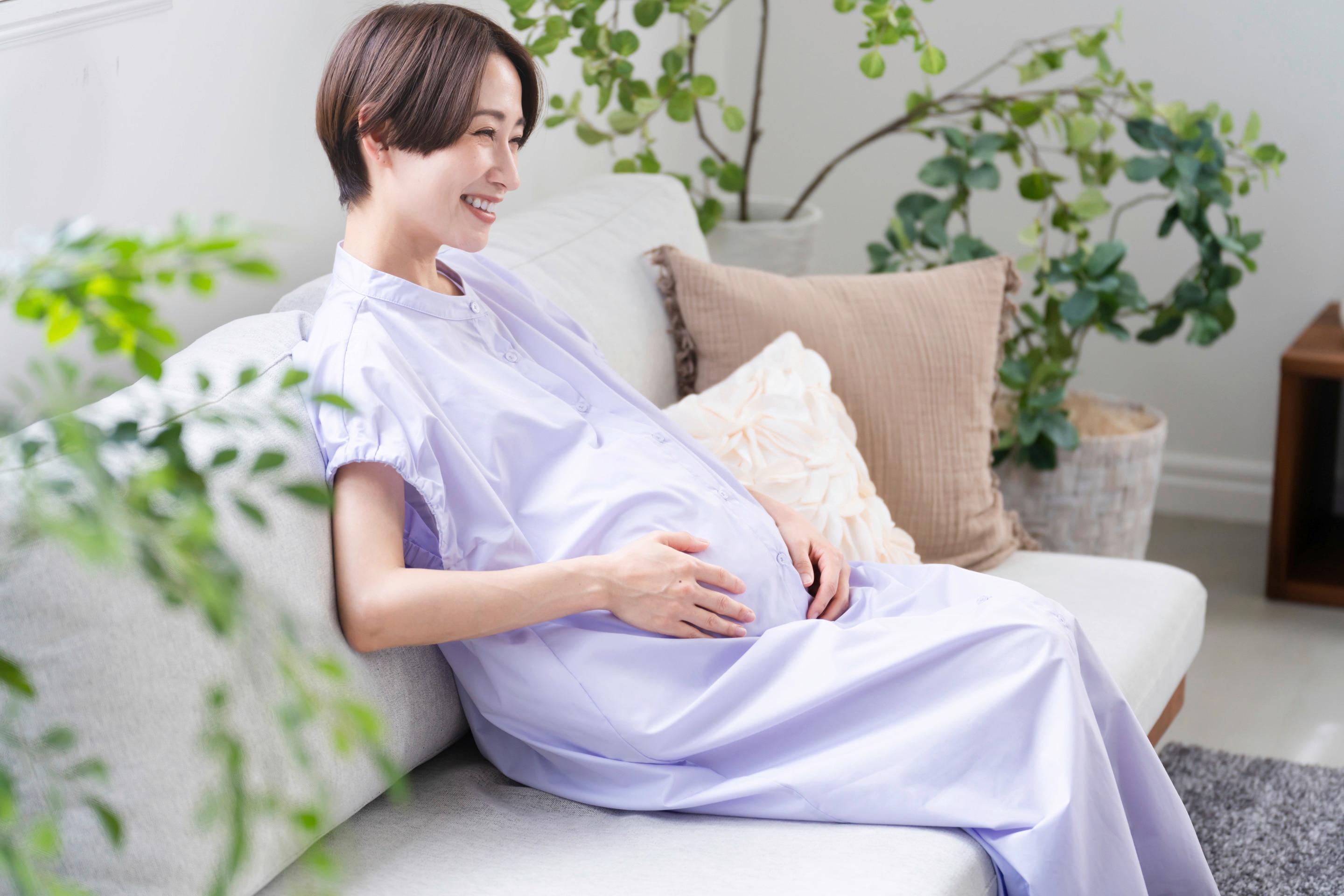 Pregnant woman lounging in a loose dress.