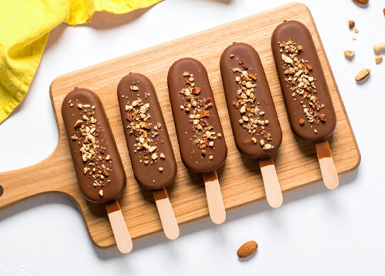 Dipped Fudgesicles on a wooden tray