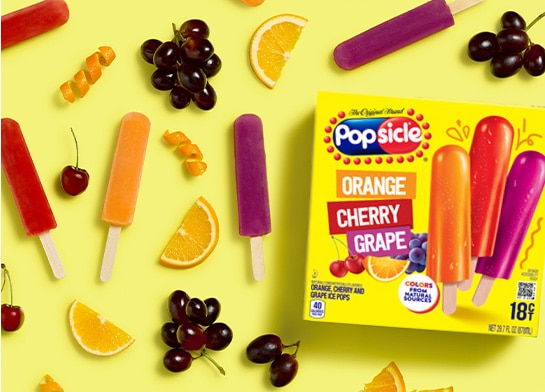 Popsicle Orange, Cherry & Grape ice pops on yellow background with fruit