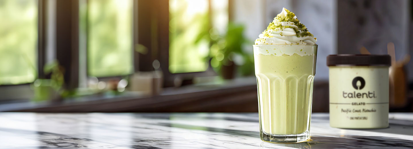 Glass of pistachio milkshake on a marble table.
