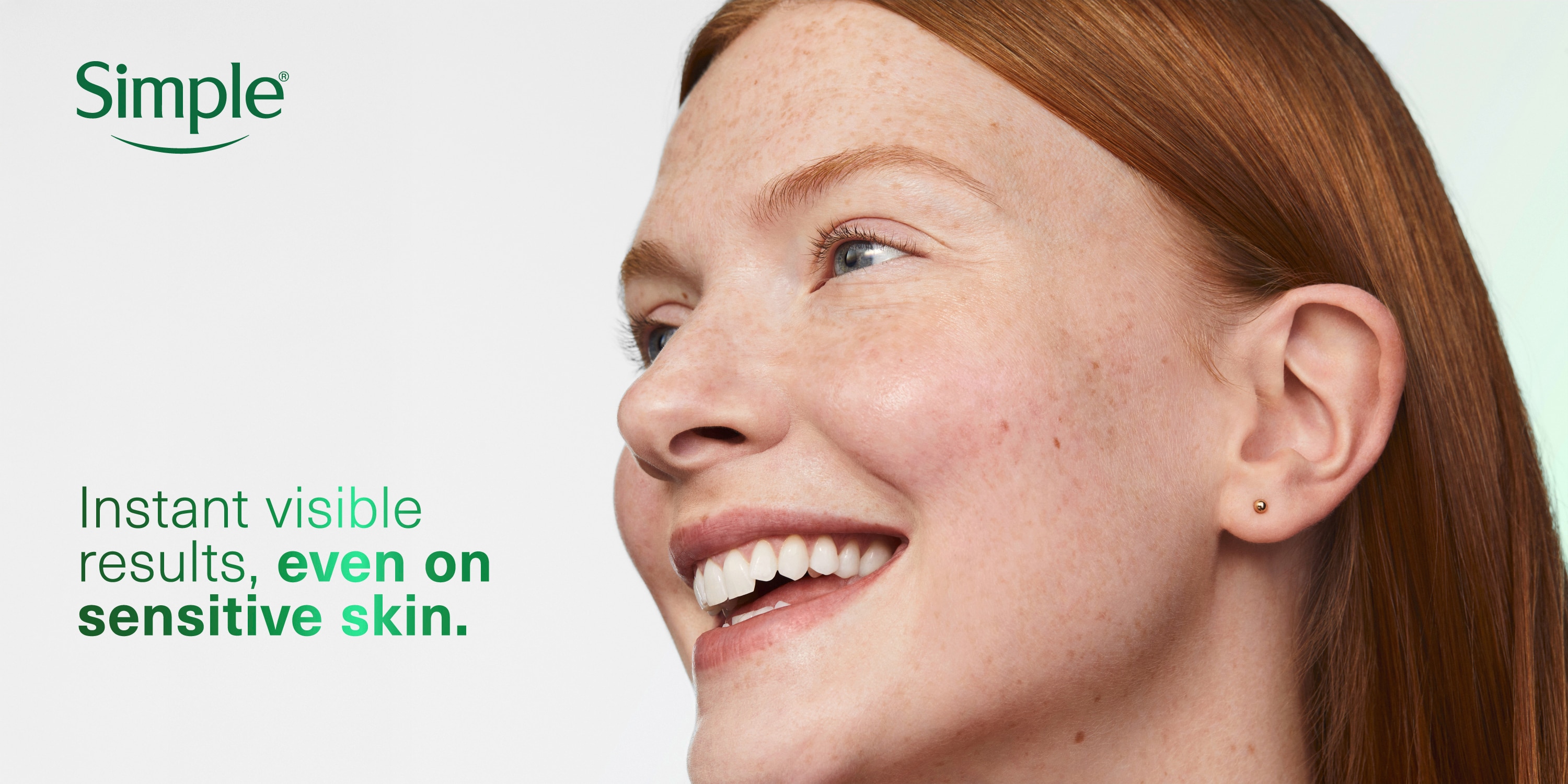 Instant visible results, even on sensitive skin.” Close-up of smiling woman with fair skin and auburn hair, showing part of face in profile view.