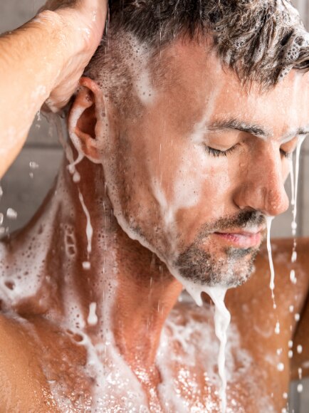 Man in shower using a body wash that hasn’t expired.