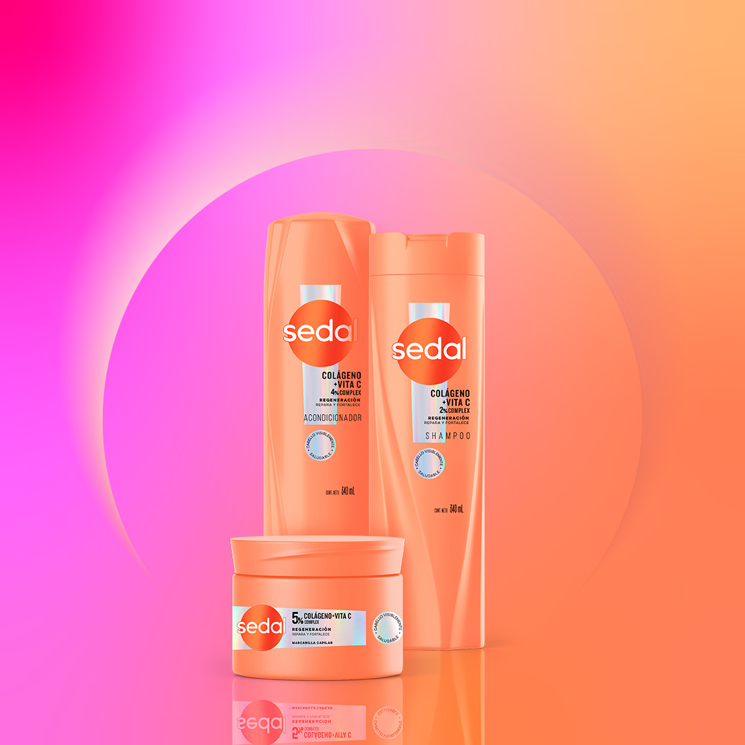 Set de productos de cuidado capilar con envases color naranja vibrante sobre fondo degradado rosa y naranja