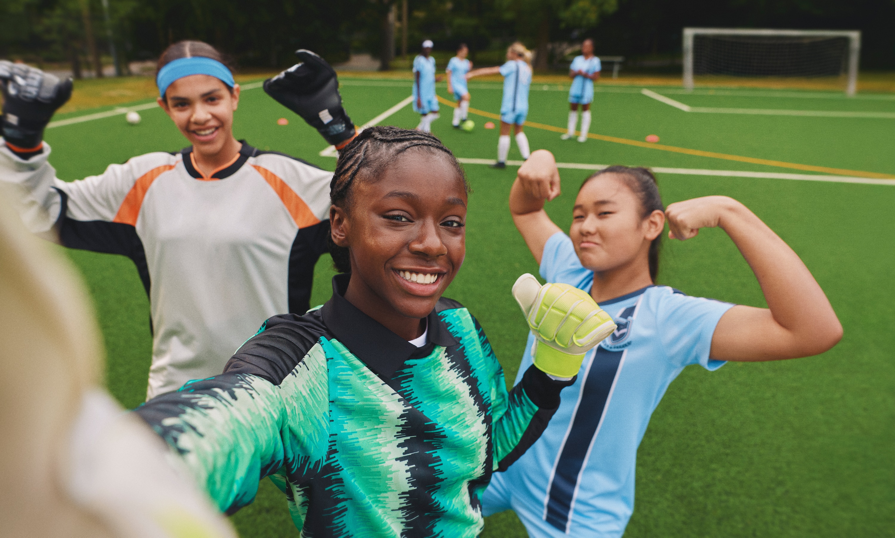 Image of three girls training on a football pitch