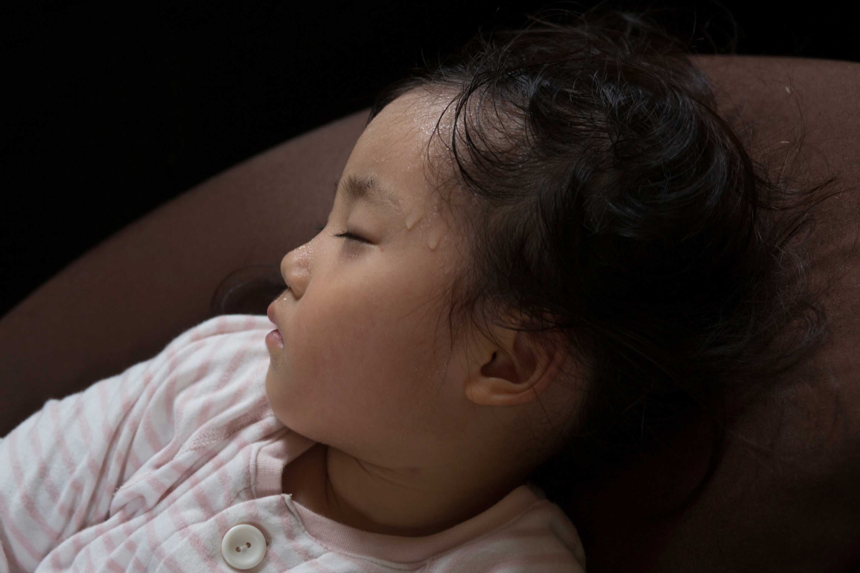 anak perempuan tertidur dengan keringat terlihat di dahinya