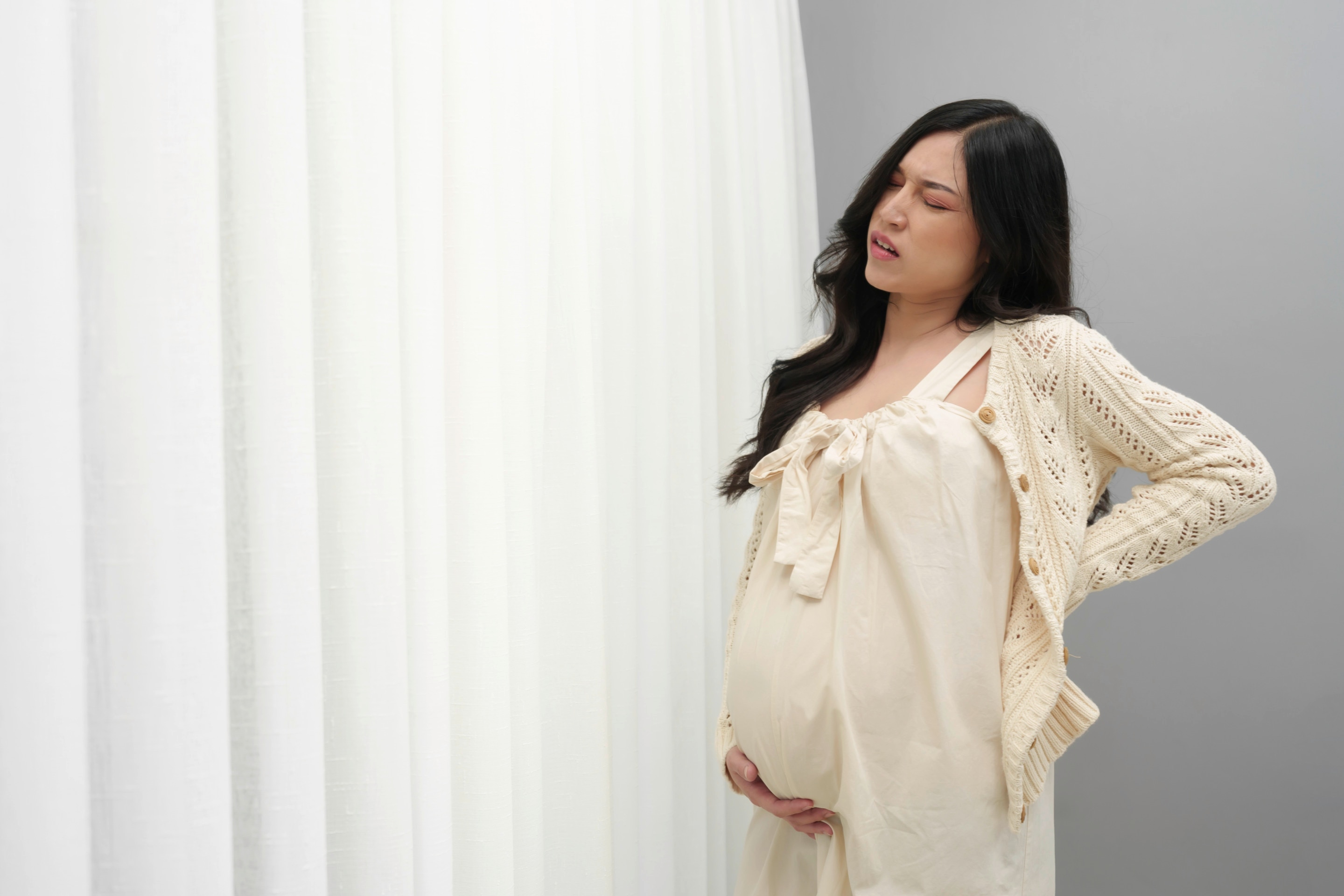 ibu hamil memegang punggung bawah karena nyeri di trimester ketiga