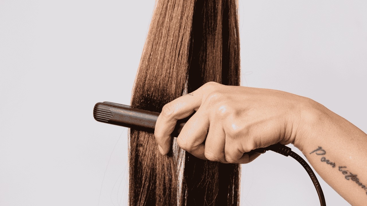 hair straightening tips woman apply serum on brown hair Tresemme Pro Pure Moisture Hair Serum