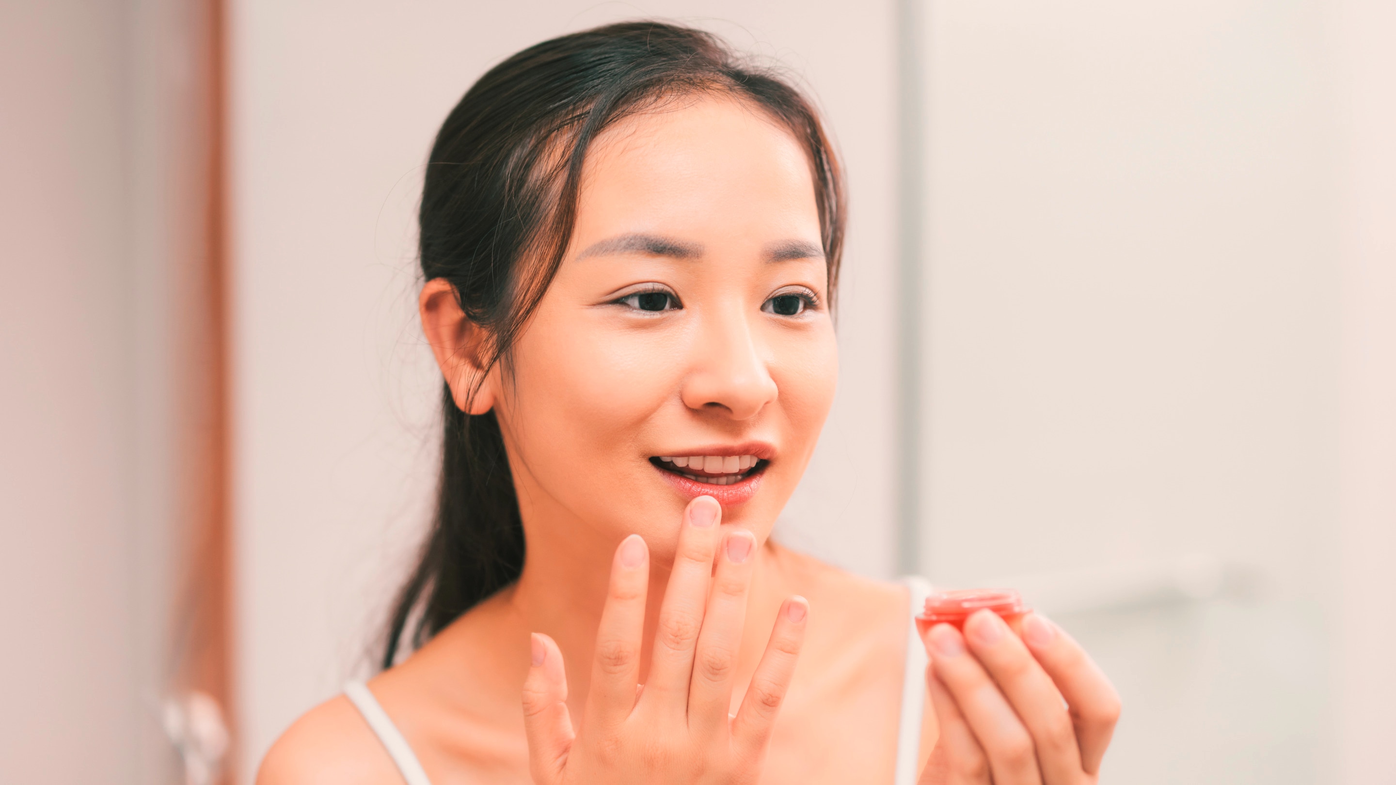 Woman applying lip balm.