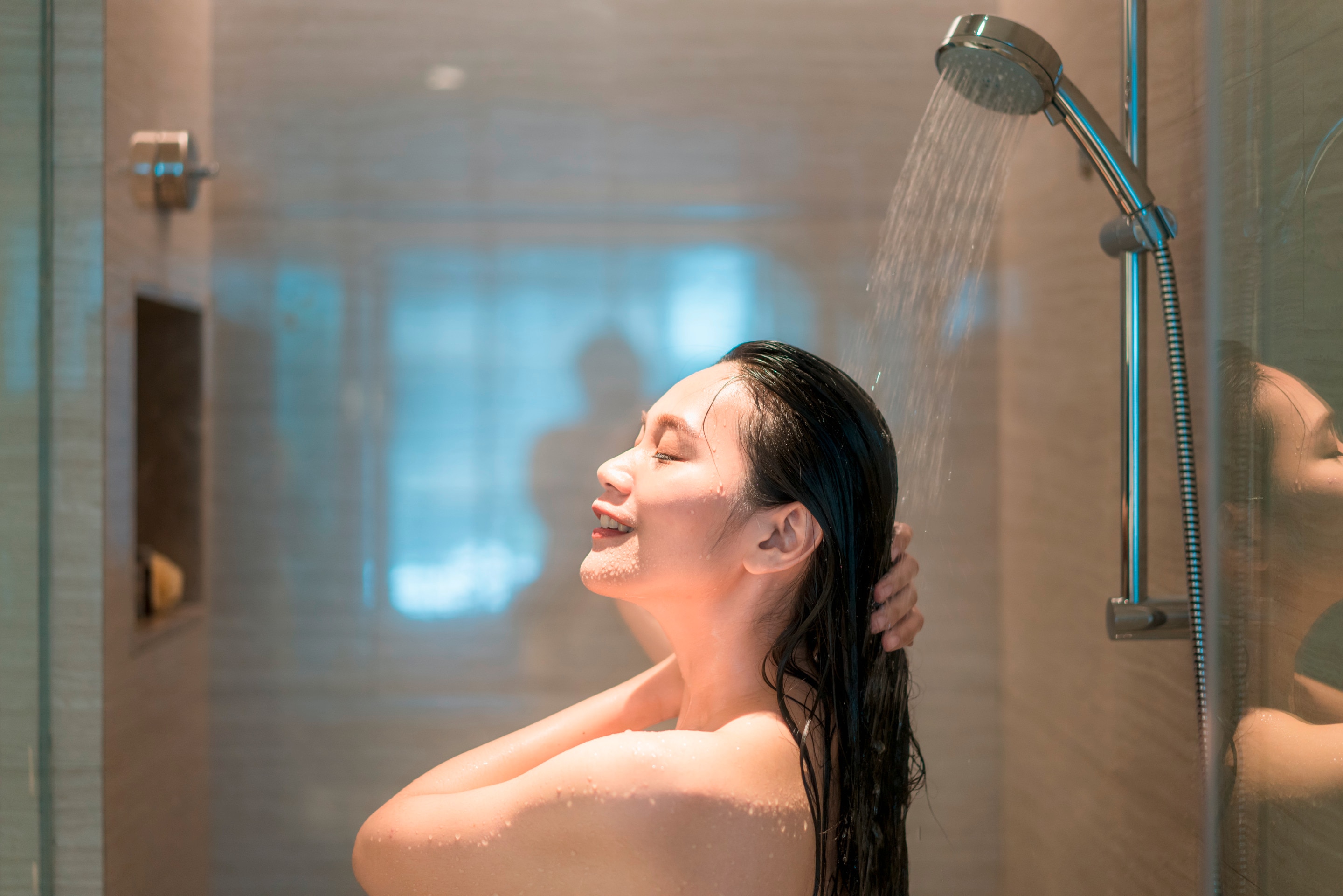 Smiling woman taking a shower.