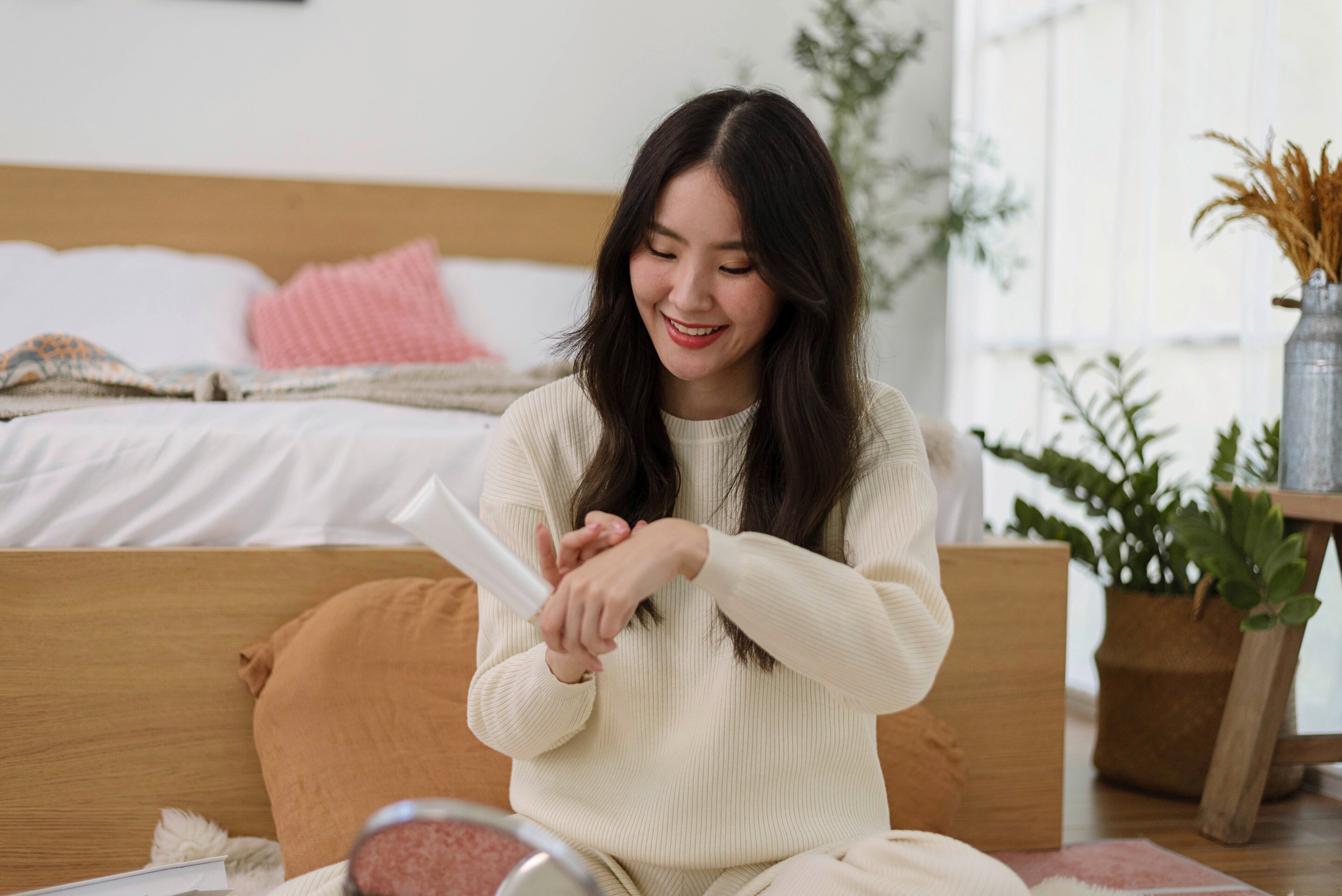 Woman applying body serum to her hand.