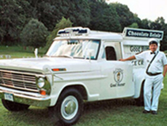 A Good Humor man posing next to his Good Humor truck.