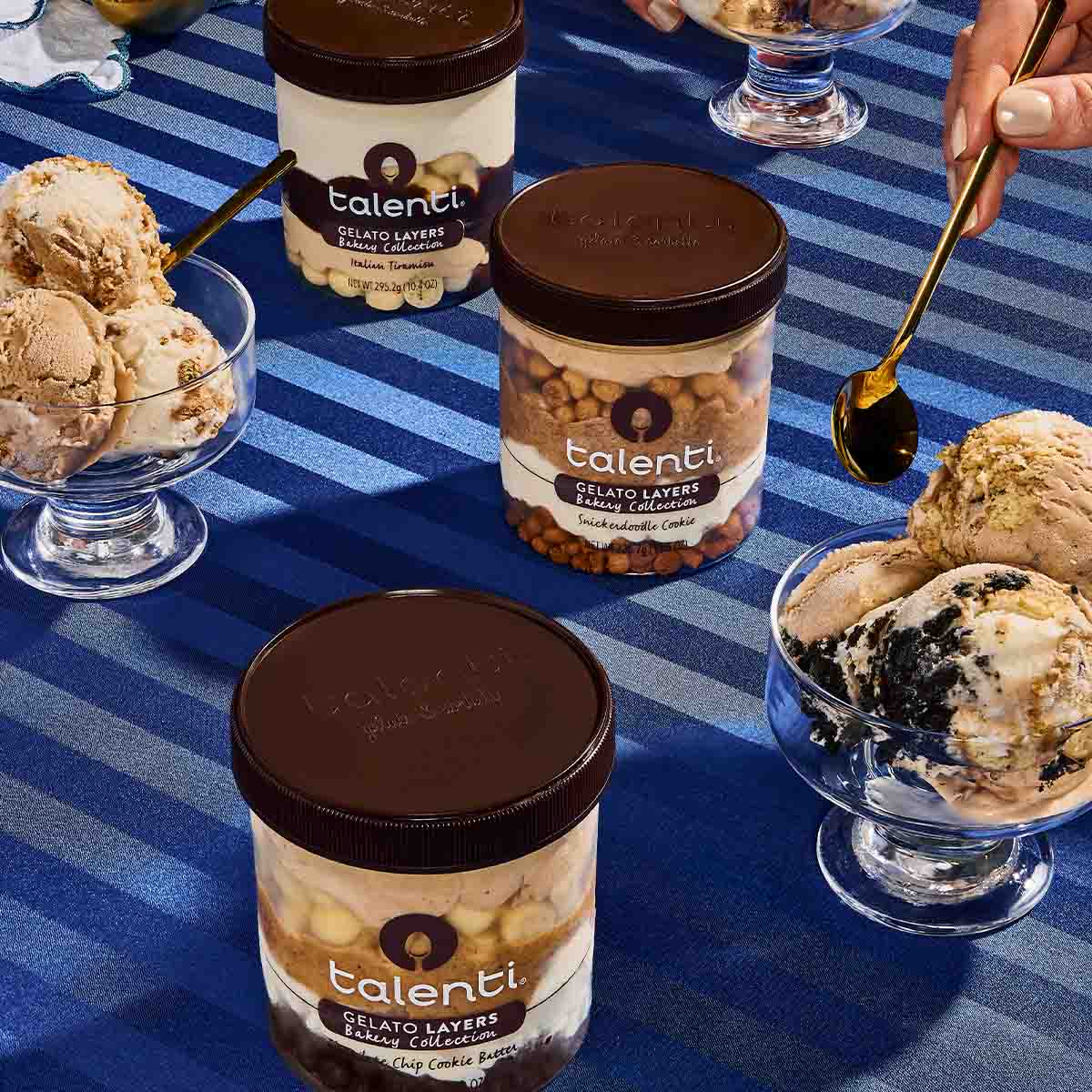 Talenti Bakery Collection Gelato Pints on a striped blue tablecloth, with gelato cups on the side.