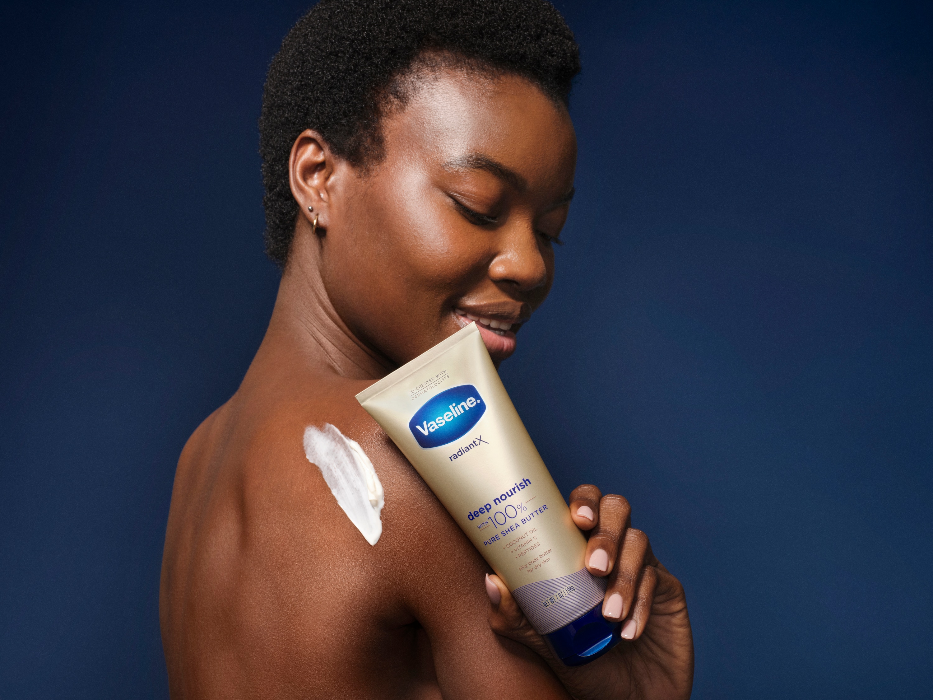 Woman holding Vaseline® Radiant X Deep Nourishment Body Cream