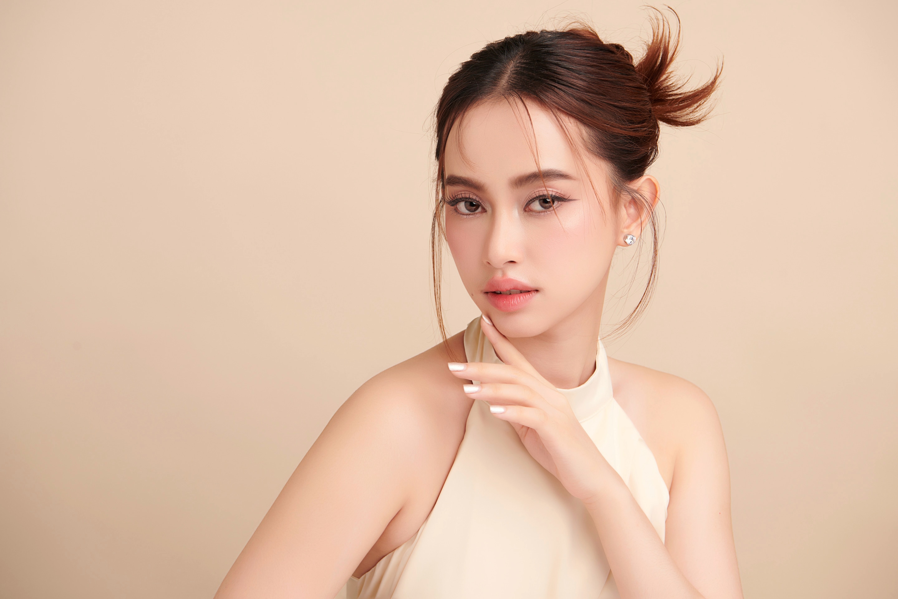 ผู้หญิงเอเชีย ผิวสวย รวบผม ใช้นิ้วแตะคาง