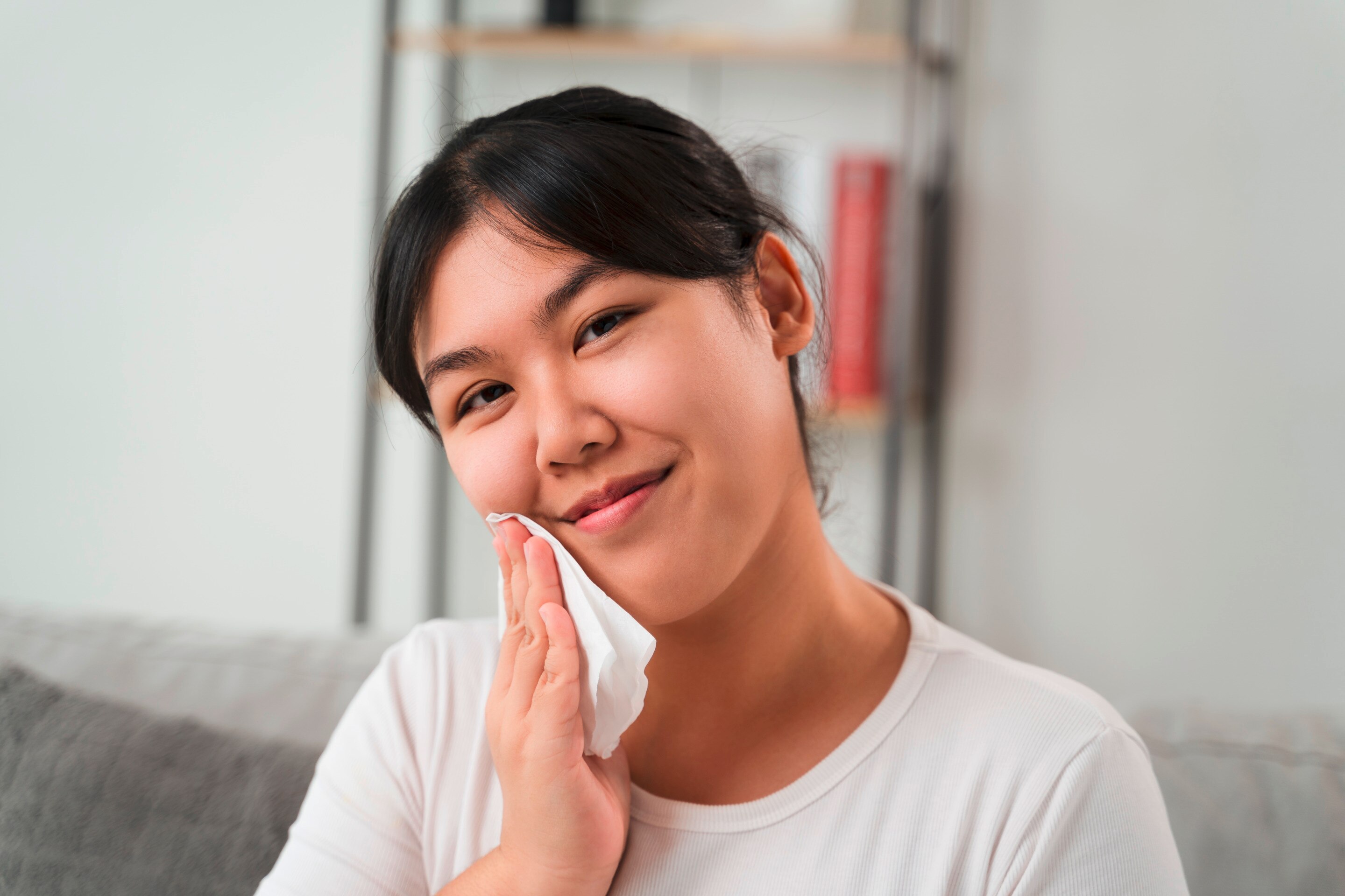 Woman wiping her face with a paper towel.