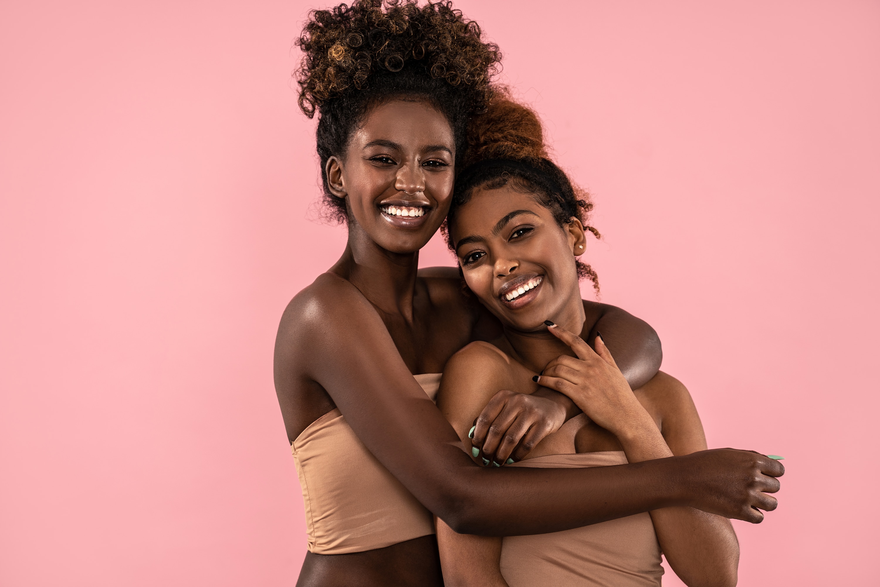 Two smiling women with glowing skin after using African black soap