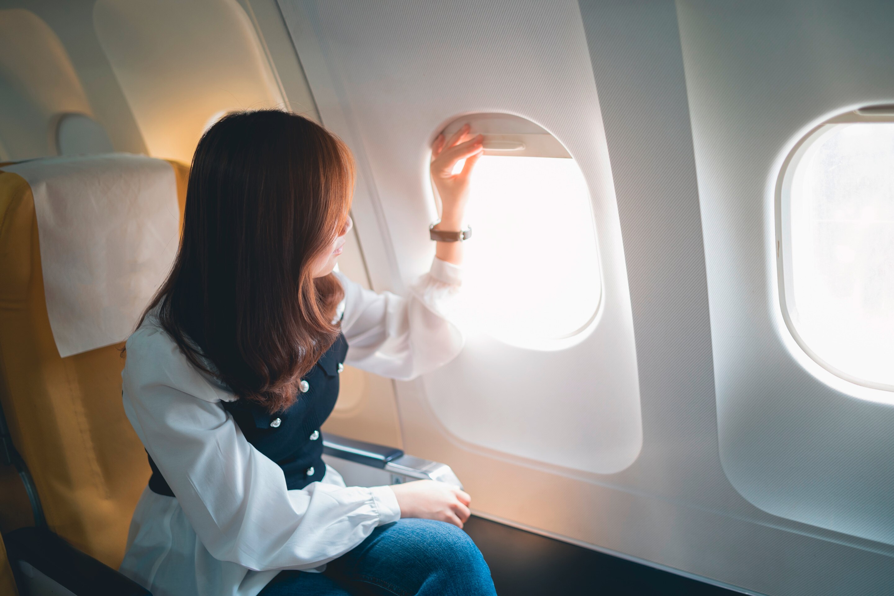 Woman looking through the airplane window.
