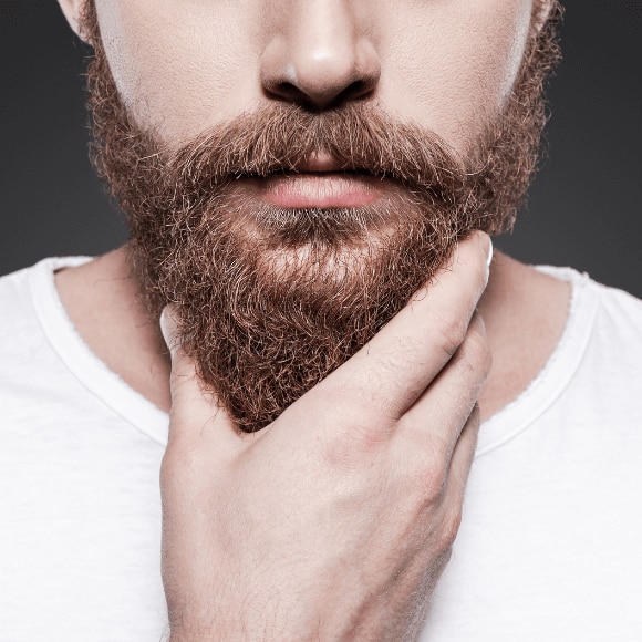 Man touching his beard wondering why his beard gets itchy