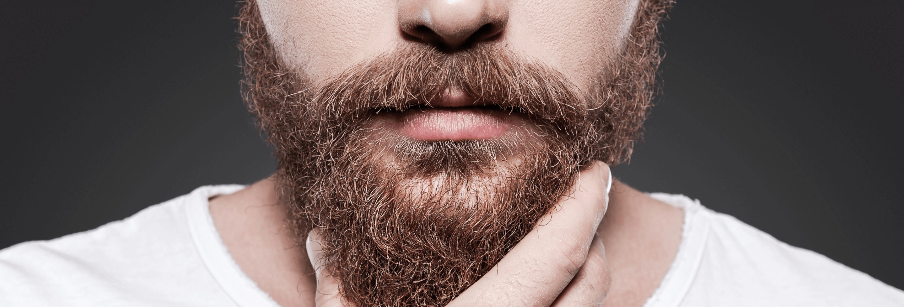 Man touching his beard wondering why his beard gets itchy