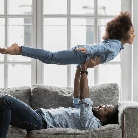 Happy strong father lifting his daughter and feeling confident after using alcohol-free deodorant