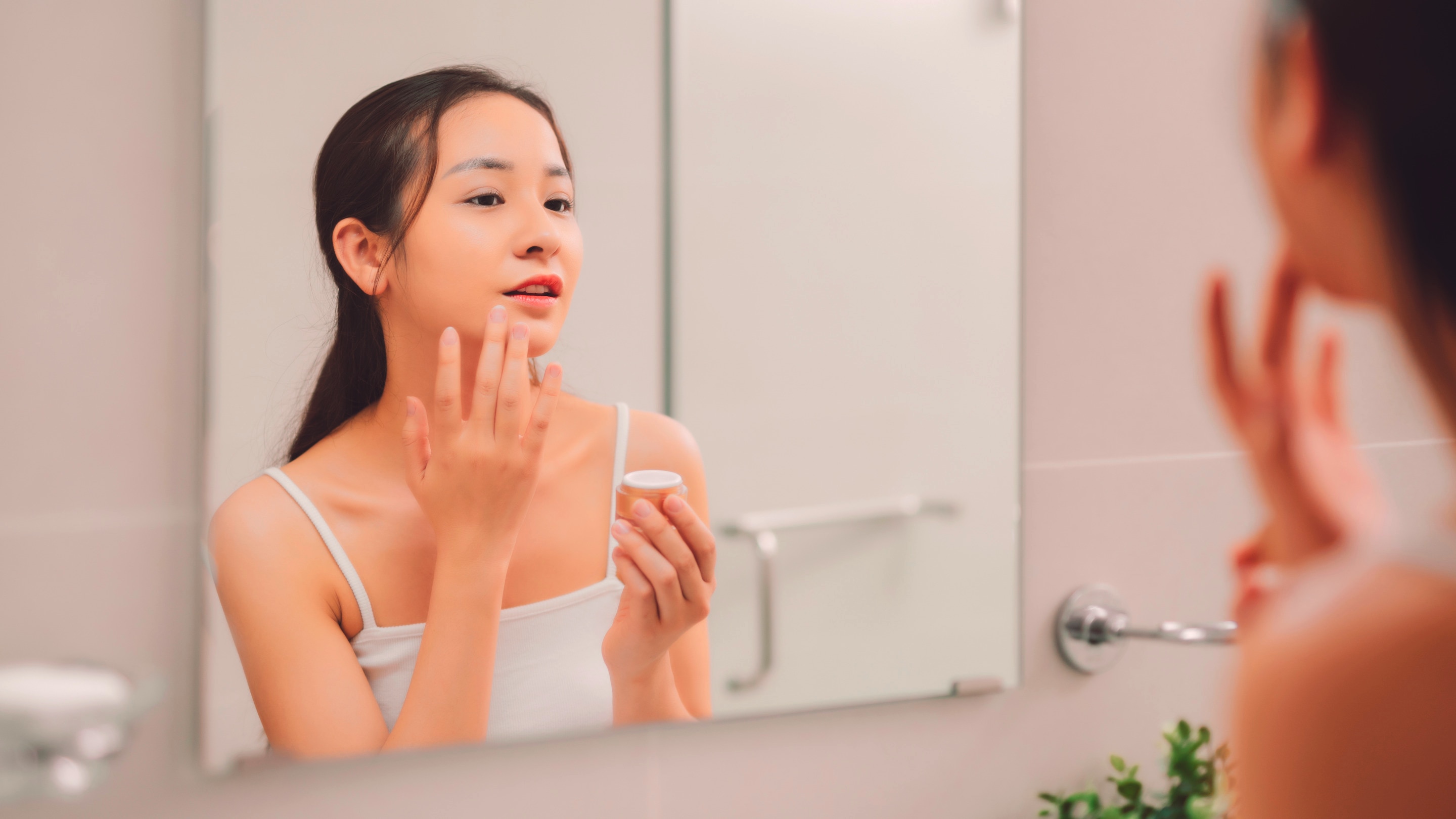 Woman applying skincare.