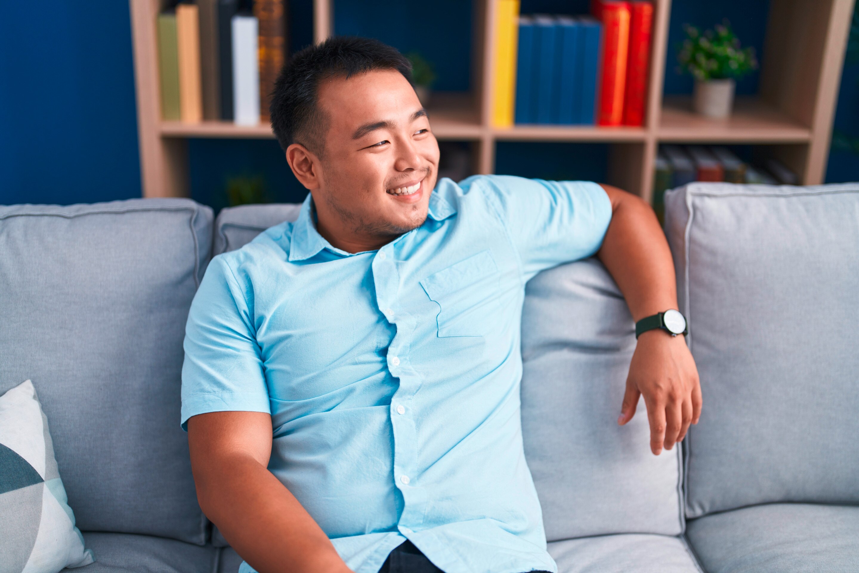 Chubby man sitting on couch.