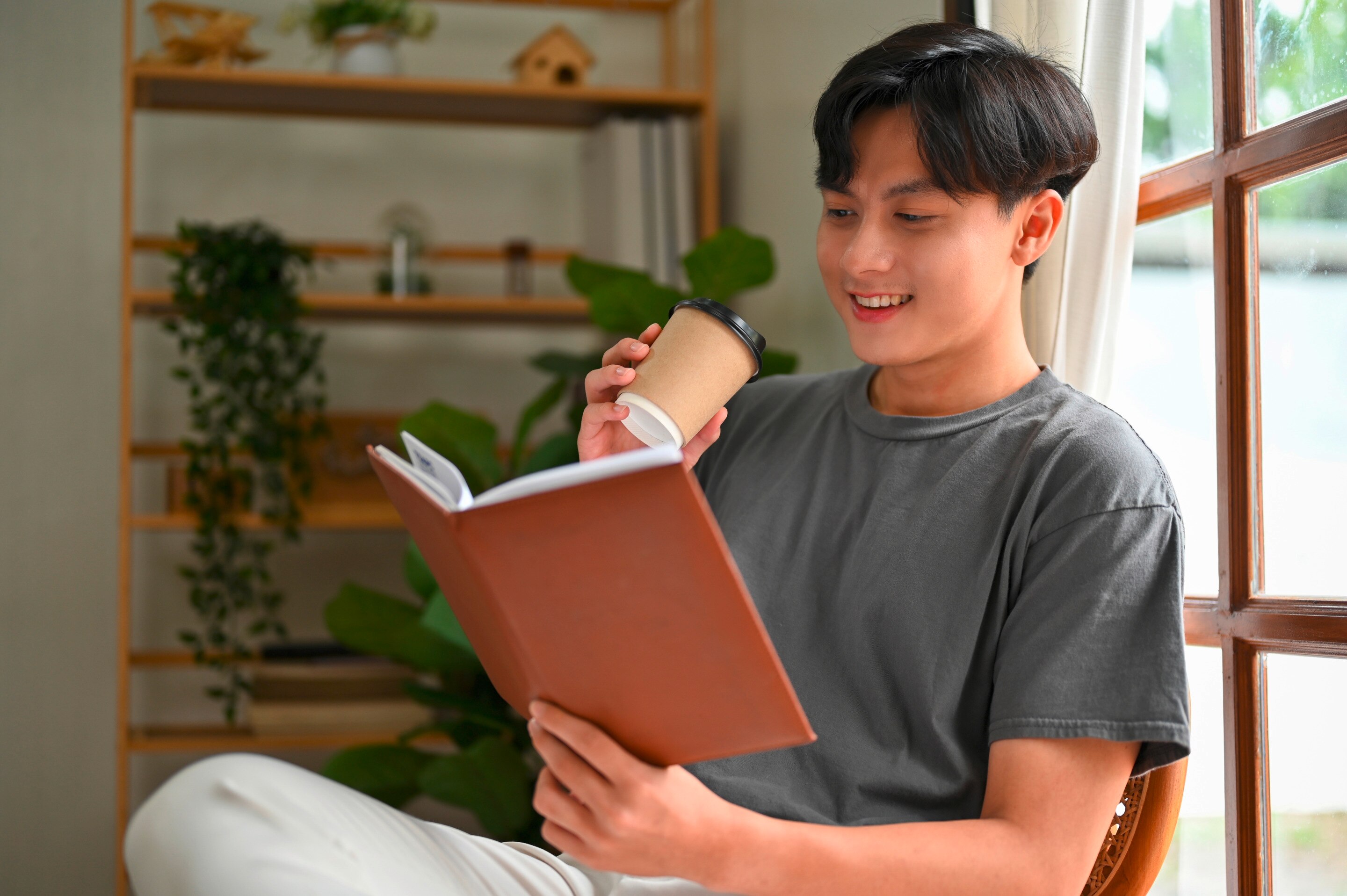 Man reading a book while sipping coffee.