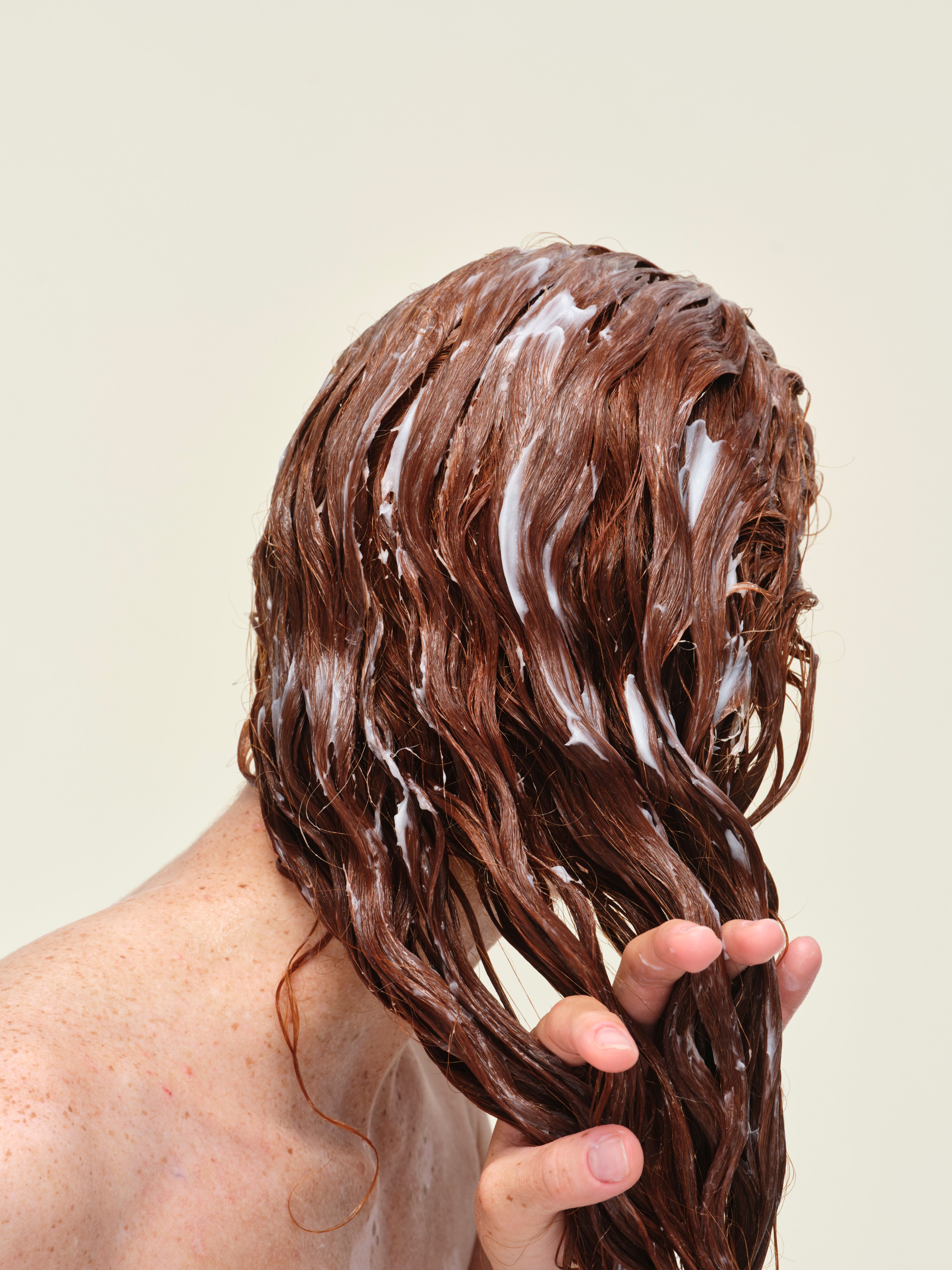 Person applying hair conditioner to wet hair
