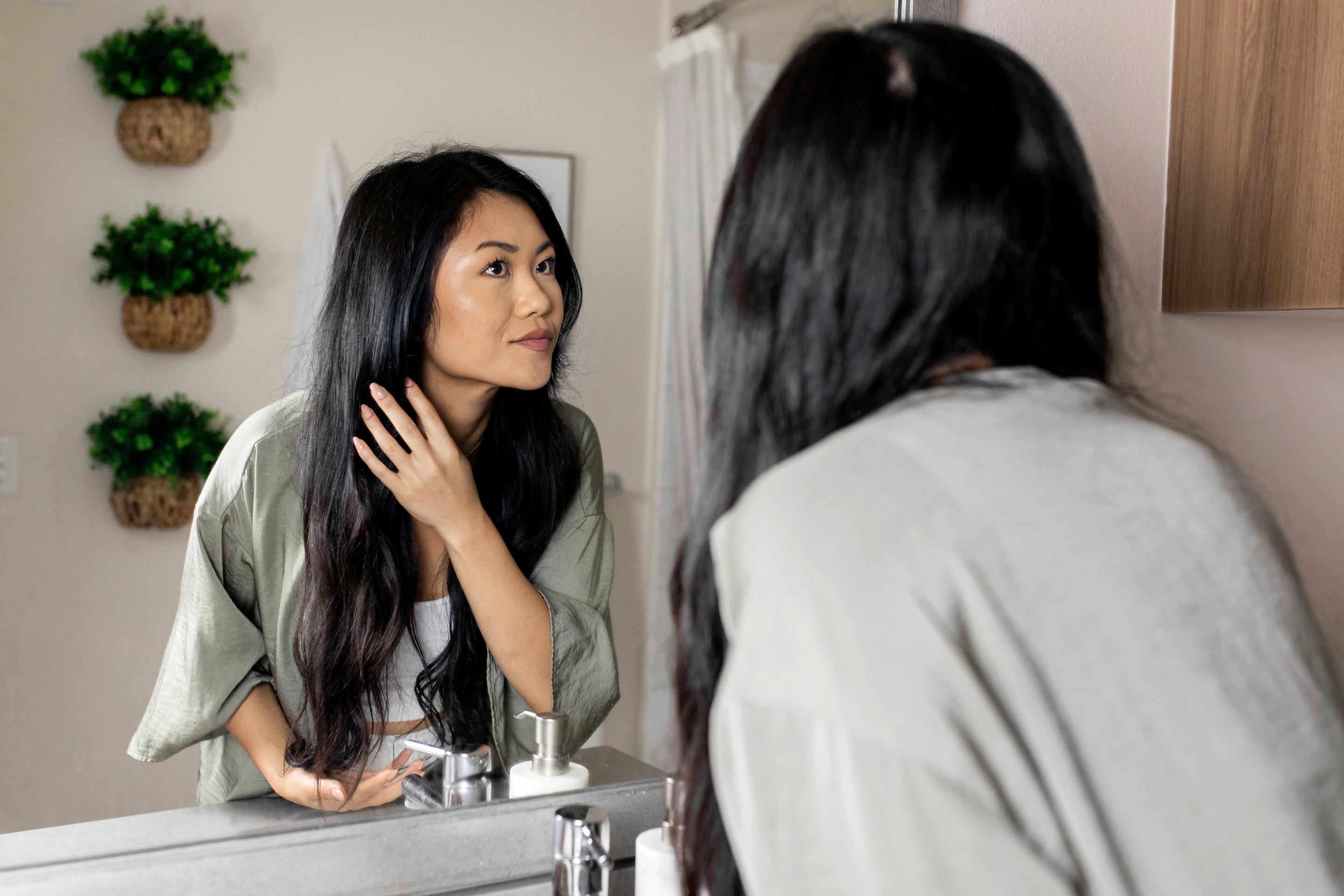 Woman checking her hair in front of mirror