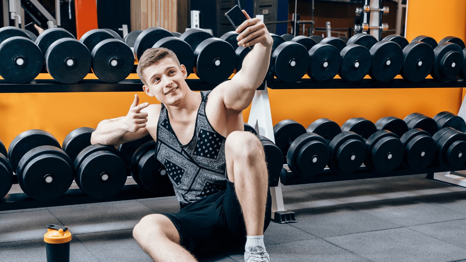 Young Gen Z male taking a selfie while respecting proper gym etiquette.