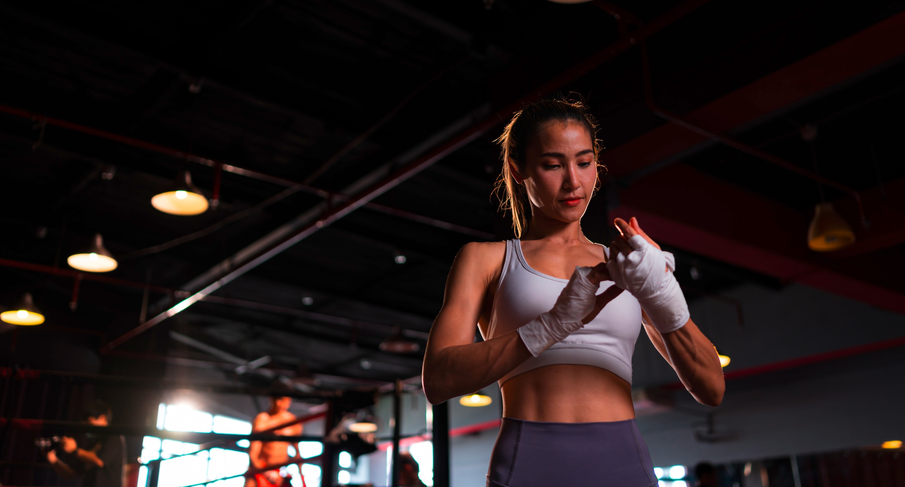 Woman in gym fixing her hand wraps.